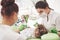 Hands of unrecognizable pediatric dentist and assistant making examination procedure for smiling cute little girl