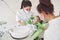 Hands of unrecognizable pediatric dentist and assistant making examination procedure for smiling cute little girl