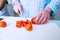 Hands of unrecognizable senior woman cutting tomatoes. Preparing