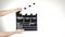 Hands use movie clapper board, on white, slow