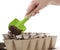 Hands Using Shovel Placing Soil into Compost Pots