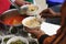 Hands of volunteers serves free food to the poor and needy in the city : The poor people bring a container to scoop food to eat