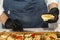 Hands of a waiter in black gloves at the buffet table. Appetizing snacks. Close-up