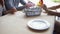 Hands of waiter serves crockery on the table for young people