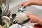 Hands wash the dishes in the old sink, in the foreground clean cutlery