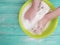 Hands washing clothes in a basin remover home worker on a wooden background