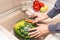 Hands washing watermelon in the sink on kitchen. Washing fruits and vegetables concept