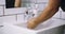 Hands, water and sink with man and handwashing, hygiene and grooming with soap during morning routine. Open faucet in