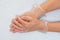 Hands wearing disposable vinyl gloves closeup on grey background, copy space.