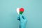 Hands wearing protective surgical gloves holding Madagascar flag heart