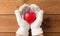 Hands in white woollen gloves holding red heart