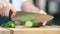 Hands of woman chef cutting fresh ripe green cucumber. Close up shot on 4k RED camera
