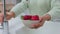 Hands of woman cleaning strawberry with water for body health, nutrition and wellness. Food, fruit and nutritionist girl