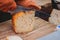 Hands of woman cutting with a knife a slice of homemade bio natural cheese