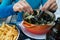 Hands of a woman eating traditional mussel and french fries dish called