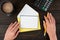 Hands Of Woman Having Blank Paper With Copy Space, Envelope, Coffee Cup And Stationery Over Wooden Table. Businesswoman