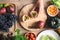 Hands of woman holding knife and cutting passion fruit on wooden board