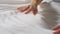 Hands of woman making bed linen