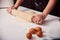 Hands of woman making dough with rolling wooden