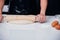 Hands of woman making dough with rolling wooden