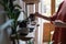 Hands of woman owner of porcelain shop arranges cups and plates on wooden shelves showcases