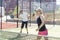 hands of a woman paddle player is holding balls and the racket at the background at the beginning of the match outdoors