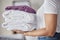 Hands, woman and pile of towel, laundry and holding a stack of neat, folded laundry in home. Female cleaning clothing