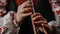 Hands of woman playing on woodwind wooden flute - ukrainian sopilka on dark background. Folk music concept. Musical