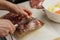 Hands of woman in process of opening vacuum package of meat on a plastic cutting board