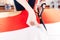 Hands of woman seamstress using scissors and cutting white fabric