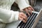 Hands of woman typing on laptop keyboard, close up view