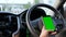 Hands of woman using using smartphone with green screen monitor at interior of SUV car for mobile application technology and tr