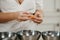 The hands of a woman who is separating the egg white from the yolk above a bowl