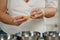 The hands of a woman who is separating the egg white from the yolk above a bowl