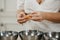 The hands of a woman who is separating the egg white from the yolk above a bowl