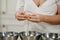 The hands of a woman who is separating the egg white from the yolk above a bowl