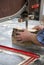 Hands of a worker sawing firewood with an industrial bandsaw