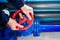 The hands of the worker Unscrew rotate the red valve to supply the gas supply. Top view close-up