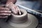 Hands working on pottery wheel , artistic toned