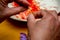 Hands working on the saffron roll with saffron flower in the background