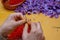 Hands working on the saffron roll with saffron flower in the background