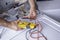 Hands working on testing circuits on a washing machine