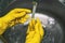 Hands in yellow protective gloves hold chemical flasks. Scientist experiment in the laboratory