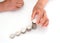 Hands with yellow skin looking down on white background are stacking dollar coins