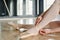 Hands of young ballerina in white tights tying silk beige ribbon on point shoe