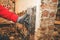 Hands of a young caucasian guy removes retro wallpaper using a steamer machine in an old house.