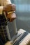 Hands of young elegant black woman holding by handle of suitcase with luggage