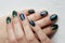 hands of a young girl with green manicure, which shows a sign of biological danger biohazard