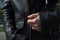 hands of a young girl who zips up on a black leather motorcycle jacket