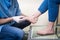 The hands of a young man doctor orthopedist conducts diagnostics, foot foot test of a woman, for the manufacture of individual, or